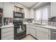 Bright kitchen featuring white cabinets, black appliances, and modern countertops offering a clean, efficient space at 2240 Highpointe Dr # 203, Laughlin, NV 89029