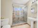 Bathroom featuring tile floors, a pedestal sink, and a glass-enclosed shower with accent tile at 2257 Colebrook St, Las Vegas, NV 89115
