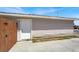 Siding detail of property with a new white door and a dark wood fence at 2257 Colebrook St, Las Vegas, NV 89115