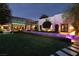 A serene backyard features a pool, manicured lawn, modern patio, and lush landscaping at 2323 Pinto Ln, Las Vegas, NV 89107