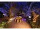 A charming outdoor dining area with custom lighting surrounded by lush landscaping at 2323 Pinto Ln, Las Vegas, NV 89107