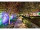 A beautifully landscaped walkway features mature trees, manicured shrubs, decorative lighting, and lush greenery at 2323 Pinto Ln, Las Vegas, NV 89107