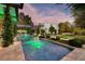 Luxury backyard featuring a long pool, fire features, and manicured landscaping at 2323 Pinto Ln, Las Vegas, NV 89107