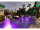 A stunning backyard pool features water fountains, fire pits, lush landscaping, and ambient lighting at 2323 Pinto Ln, Las Vegas, NV 89107