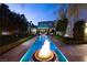 Backyard features a long pool with fire bowls and a meticulously manicured lawn at 2323 Pinto Ln, Las Vegas, NV 89107