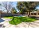 Lush backyard with artificial turf, mature tree, and a sparkling in-ground pool perfect for outdoor relaxation at 2617 Mason Ave, Las Vegas, NV 89102
