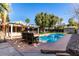 A delightful backyard featuring an in-ground pool, covered patio with seating, and lush landscaping at 2617 Mason Ave, Las Vegas, NV 89102