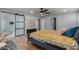 This bedroom features wood flooring, ceiling fan, art on the wall, closet, barn door to bathroom, and windows at 2617 Mason Ave, Las Vegas, NV 89102