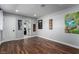 Spacious room with hardwood floors and light gray walls, showcasing guitar-themed artwork and access to other rooms at 2617 Mason Ave, Las Vegas, NV 89102