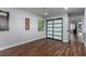 Spacious room with hardwood floors and light gray walls, showcasing guitar-themed artwork and access to other rooms at 2617 Mason Ave, Las Vegas, NV 89102