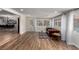 Open-concept living space with hardwood floors, a classic sofa, and views of the dining area and pool, ideal for modern living at 2617 Mason Ave, Las Vegas, NV 89102