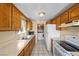 Kitchen featuring wooden cabinets, appliances, and tile flooring, with a laundry area visible in the background at 2821 Geist Cir, Las Vegas, NV 89115
