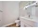Well-lit half bathroom featuring a white vanity, modern faucet, and a glass block window at 2904 Bow Bridge Dr, Las Vegas, NV 89134