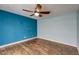 Bright bedroom features wood flooring, a ceiling fan, and light blue walls at 3062 El Camino Ave, Las Vegas, NV 89102