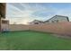 Home featuring a spacious backyard with artificial grass, a wall, and clear sky at 361 Andy Wheeler Dr, Henderson, NV 89011