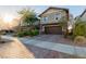 Inviting two-story home featuring a brick driveway, lush landscaping, and a two-car garage at 361 Andy Wheeler Dr, Henderson, NV 89011