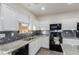 Well-equipped kitchen featuring white cabinets, granite countertops, and modern stainless steel appliances at 361 Andy Wheeler Dr, Henderson, NV 89011
