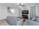 Comfortable living room with neutral tones, wood-look tile floors, and an open staircase at 361 Andy Wheeler Dr, Henderson, NV 89011