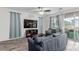 Inviting living room with stylish sofas, wood-look tile floors, and a sliding glass door to the backyard at 361 Andy Wheeler Dr, Henderson, NV 89011