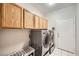 Clean laundry room featuring wooden cabinets and a modern washer and dryer at 417 Carlton Kay Pl, Las Vegas, NV 89144