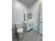 Modern bathroom with white vanity, square mirror, and grey wood-look flooring at 4844 E Cactus Canyon Dr, Pahrump, NV 89061