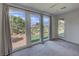 Well-lit bedroom with large windows showcasing landscaped backyard, carpeted floors, and modern ceiling fan at 4844 E Cactus Canyon Dr, Pahrump, NV 89061