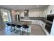 Modern kitchen features center island, bar seating, stainless appliances, and white cabinetry at 4844 E Cactus Canyon Dr, Pahrump, NV 89061
