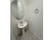 Compact powder room features pedestal sink, oval mirror and ceramic tile flooring at 4844 E Cactus Canyon Dr, Pahrump, NV 89061