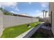 Backyard with a green lawn, stone path, and privacy wall at 4940 Mascaro Dr, Las Vegas, NV 89122