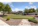 Backyard putting green surrounded by trees, shrubbery and decorative gravel provides at home recreation at 4940 Mascaro Dr, Las Vegas, NV 89122