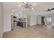 Open concept living area with modern kitchen, wood-look floors, and access to multiple rooms at 5020 Village Dr, Las Vegas, NV 89142