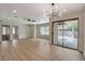 Open-concept living area featuring light wood floors, neutral walls, and glass sliding doors to the outside at 5020 Village Dr, Las Vegas, NV 89142