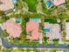 Stunning aerial view of luxury homes featuring tile roofs, mature landscaping, sparkling pools, and green lawns at 517 Spruce Canyon St, Las Vegas, NV 89144