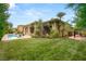 Expansive backyard featuring a sparkling pool, lush green lawn, mature trees, and a covered patio for outdoor entertaining at 517 Spruce Canyon St, Las Vegas, NV 89144