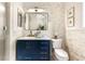A sleek bathroom with a navy vanity, granite countertop, brass faucet, and modern fixtures for a touch of elegance at 517 Spruce Canyon St, Las Vegas, NV 89144
