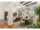 Open-concept dining area with a wooden table, chandelier, and natural light from large windows at 517 Spruce Canyon St, Las Vegas, NV 89144