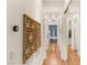 Hallway with wood floors, thermostat, and decorative wall art with mirrored closet doors at 517 Spruce Canyon St, Las Vegas, NV 89144