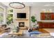 Bright living room with stone fireplace and large windows, seamlessly connecting to the kitchen area at 517 Spruce Canyon St, Las Vegas, NV 89144