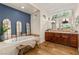 Main bathroom features a soaking tub, wood floors, decorative lighting, and vanity with double sinks at 517 Spruce Canyon St, Las Vegas, NV 89144