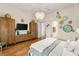 A bright main bedroom featuring wood floors, a chandelier, dresser, and decorative wall art at 517 Spruce Canyon St, Las Vegas, NV 89144
