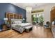 Main bedroom with a chandelier, wood floors, decorative headboard, and outdoor access at 517 Spruce Canyon St, Las Vegas, NV 89144