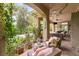 Charming covered patio area with a comfortable lounge chair, a table, and views of the lush backyard and pool at 517 Spruce Canyon St, Las Vegas, NV 89144