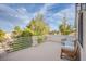 Relaxing outdoor balcony features neutral-toned furnishings and railings with views of mature trees and neighborhood at 5180 N Dapple Gray Rd, Las Vegas, NV 89149