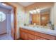 Bathroom featuring double sinks, vanity with tile countertop, and custom mirror with cabinets at 5180 N Dapple Gray Rd, Las Vegas, NV 89149