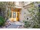 Inviting front entrance features a stylish wood door with decorative glass panels and lush landscaping at 5180 N Dapple Gray Rd, Las Vegas, NV 89149
