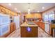A kitchen with an island featuring wooden cabinets, granite countertops, and modern appliances for cooking at 5180 N Dapple Gray Rd, Las Vegas, NV 89149