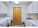 Well-lit laundry room with washer, dryer, cabinetry, sink, and ample counter space at 5180 N Dapple Gray Rd, Las Vegas, NV 89149