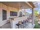 Outdoor kitchen with bar seating, ceiling fan, and grill in the covered patio area at 5180 N Dapple Gray Rd, Las Vegas, NV 89149