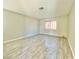 Spacious room with neutral walls, light-filled window, and stylish wood-look flooring at 5215 Gray Ln, Las Vegas, NV 89119