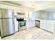 Bright kitchen featuring stainless steel appliances, white cabinets, and lovely wood-look flooring at 5215 Gray Ln, Las Vegas, NV 89119